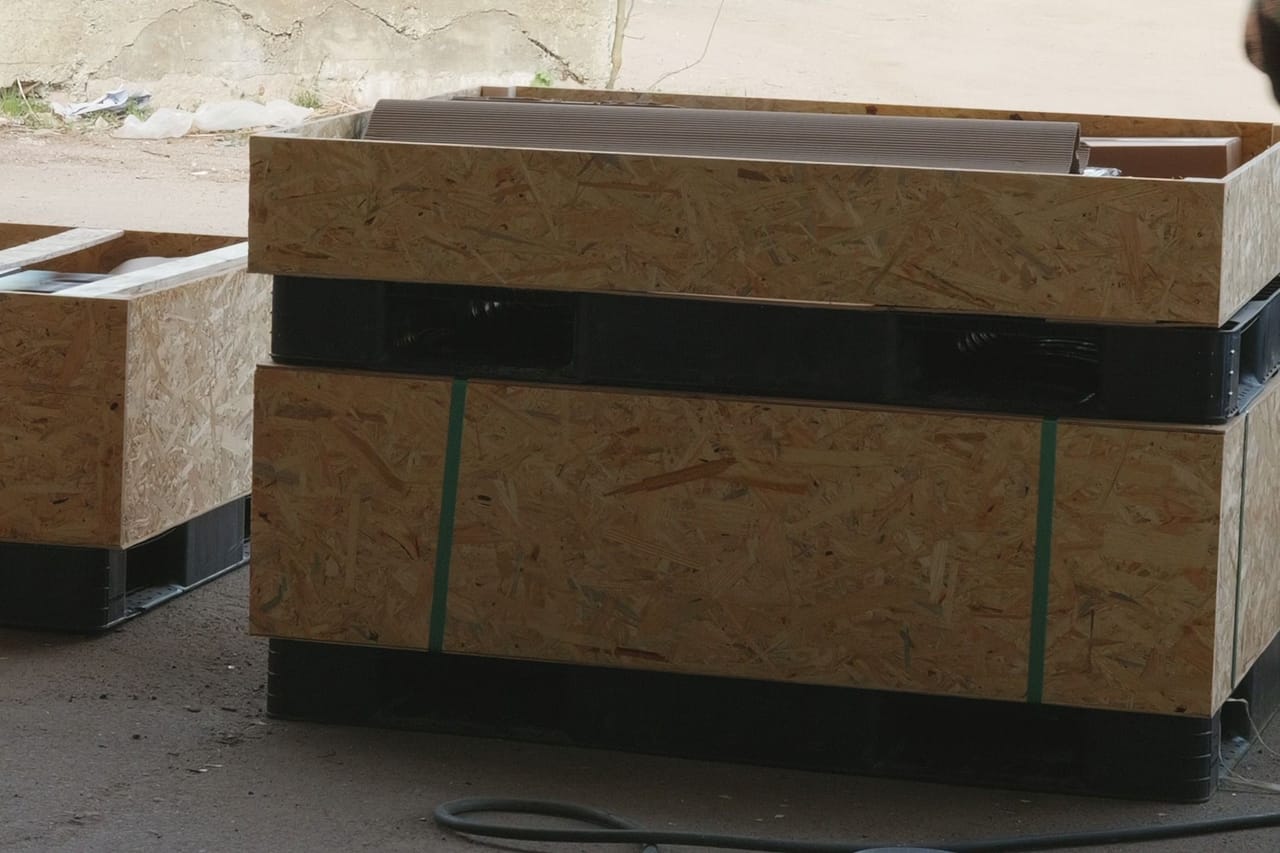 Two plywood and OSB crates strapped on a pallet, outdoors