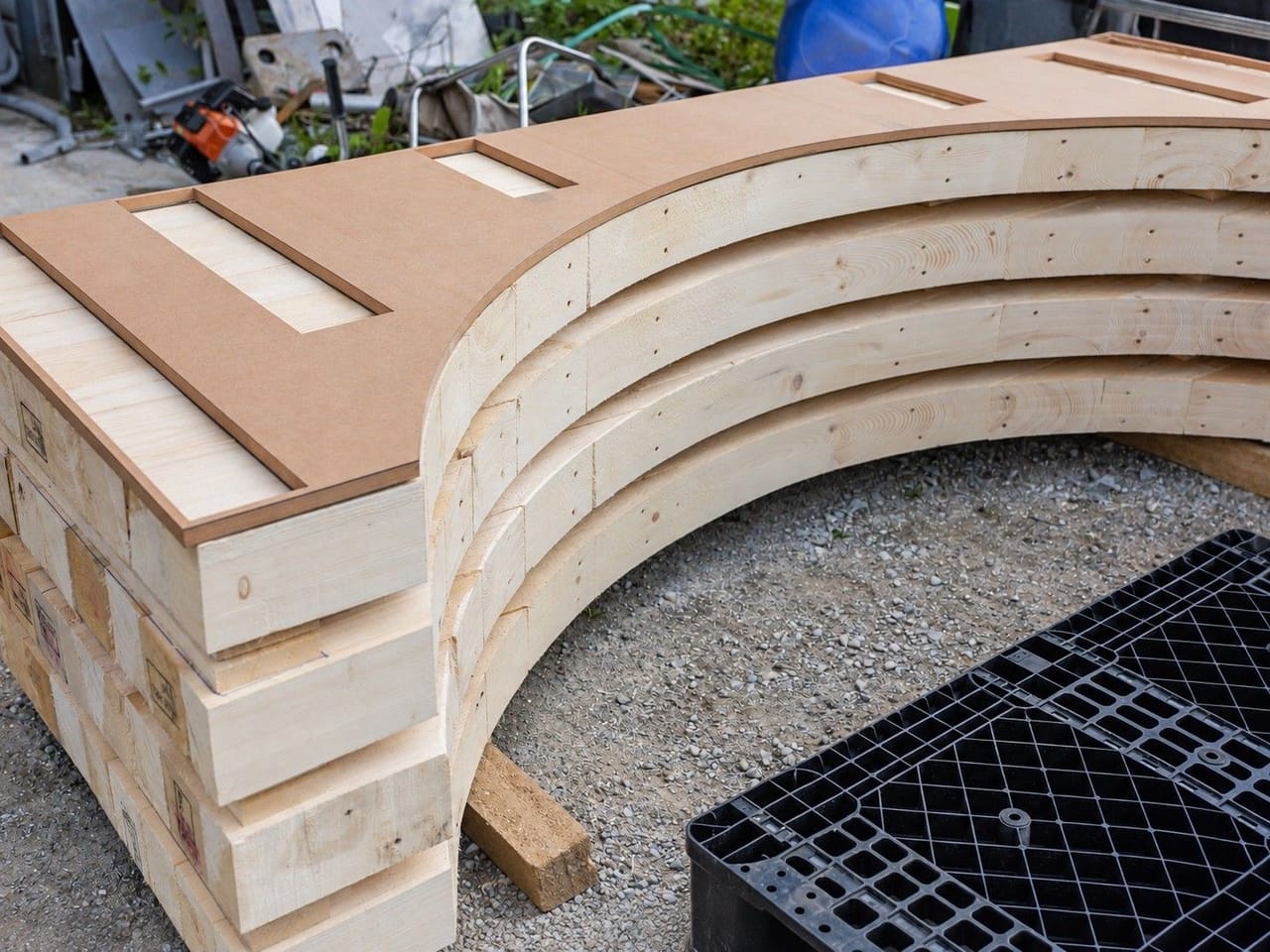 Curved cradle made from layered plywood and timber on a plastic pallet